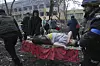 Bildet er av en kvinne på et rødt teppe, som ligger på en båre. Hun er synlig gravid og skadd. Hun er omgitt av redningsmannskap og ruiner. Sykehuset ble bombet. Foto: Evgeniy Maloletka / AP / NTB