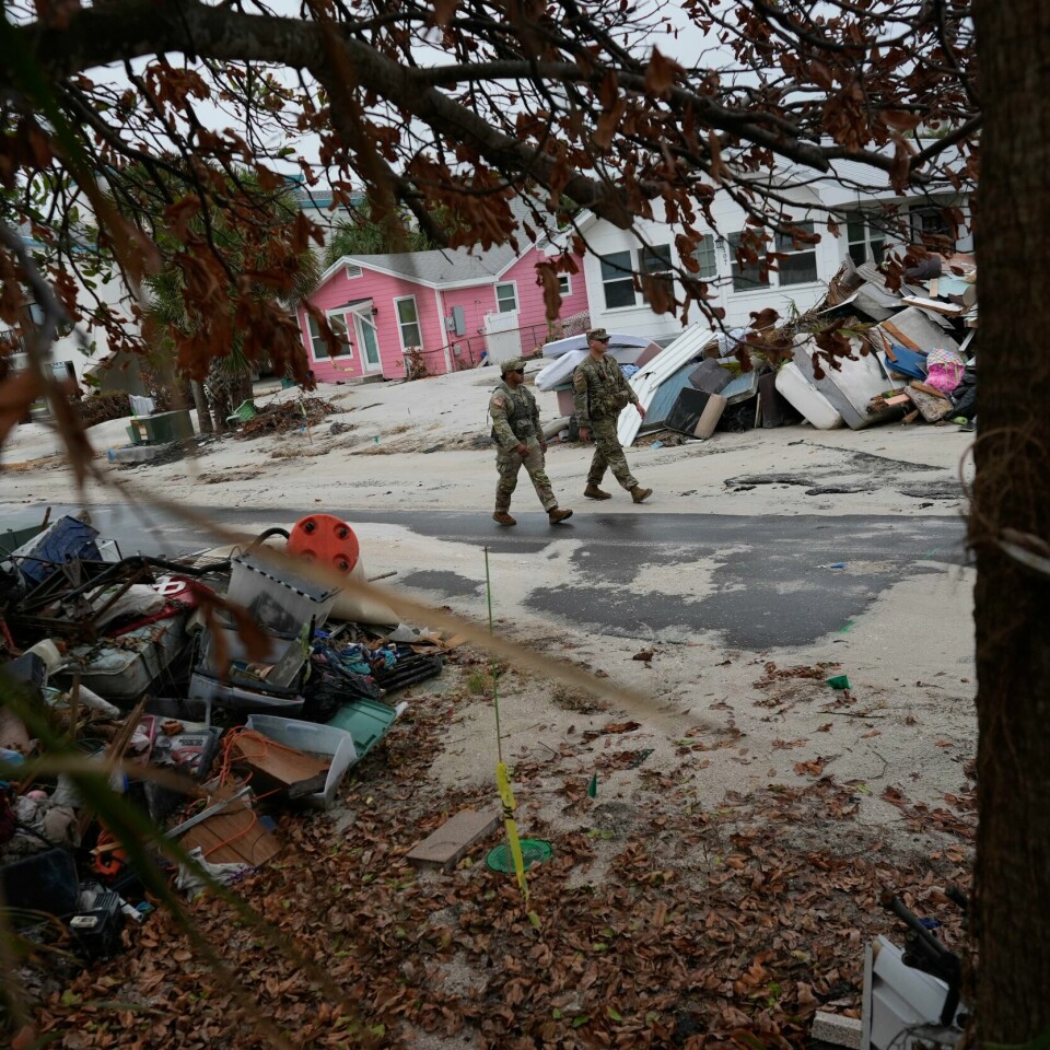 EVAKUERING: Her går amerikanske soldater rundt for å sjekke at folk har evakuert fra hjemmene sine. Rotet som ligger rundt er fortsatt igjen fra orkanen «Helena» forrige uke. Floridas nasjonalgarde leter etter folk som har blitt værende i Bradenton Beach, der gatene stadig er fulle av skrot etter orkanen Helene. Innbyggere er beordret til å evakuere i elleve fylker i Florida. Foto: Rebecca Blackwell / AP / NTB