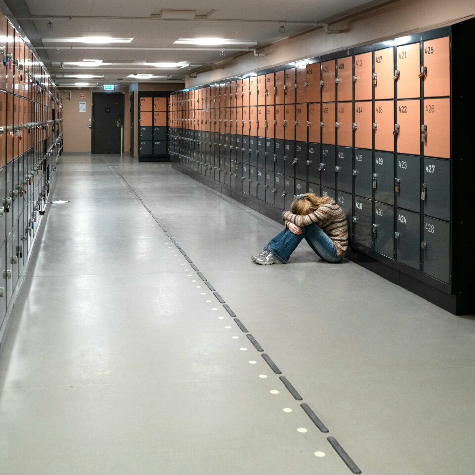 PSYKISK HELSE: Folk som er ensomme opplever mindre mening i livet. Bildet viser en ung jente som sitter alene i gangen på en skole. Foto: Gorm Kallestad / NTB