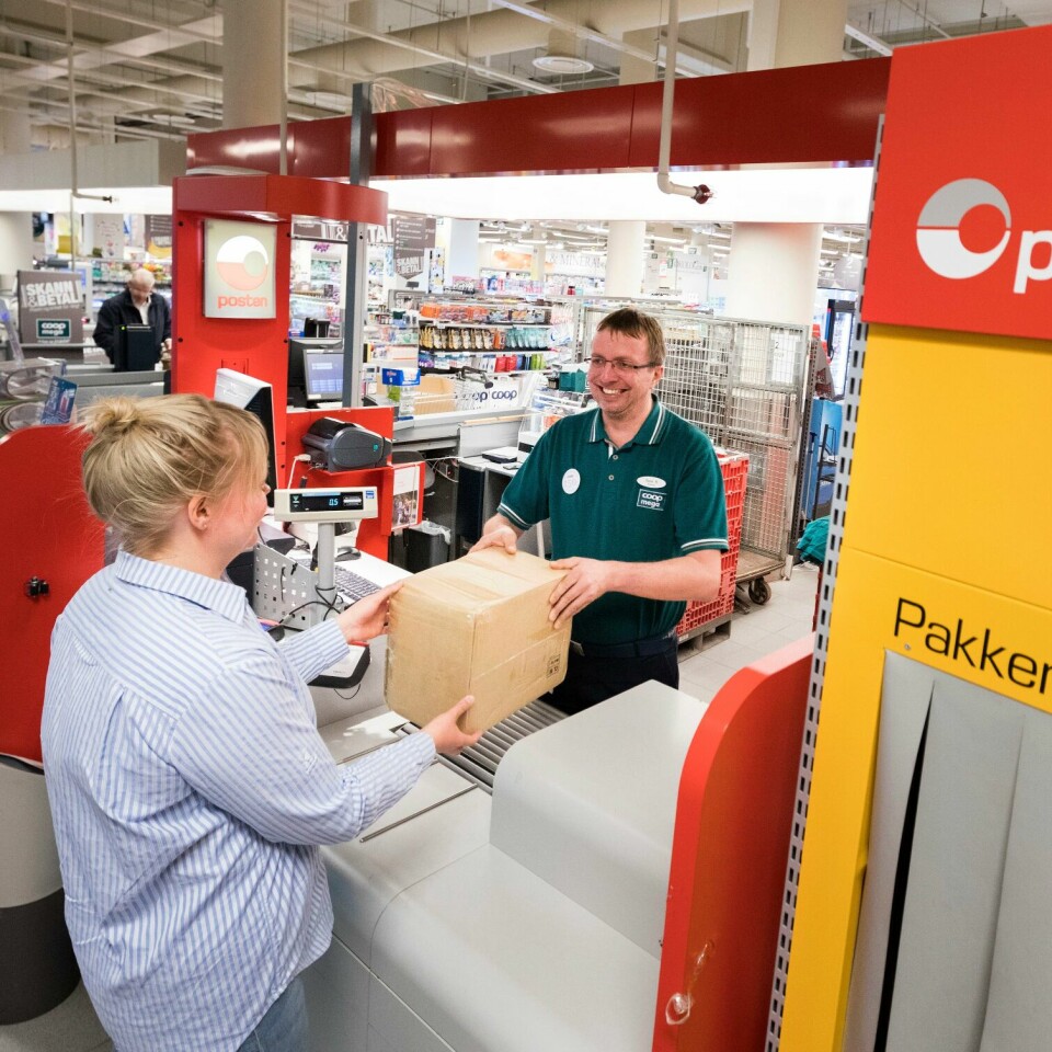 TRAVELT: Posten har travle dager før jul. Bildet viser en kvinne som henter en pakke på et postkontor. Illustrasjonsfoto: Gorm Kallestad / NTB / NPK