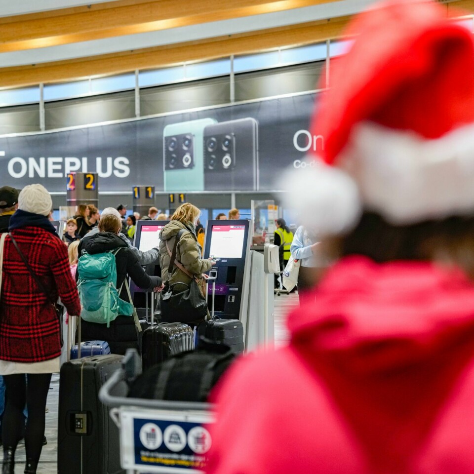 JULEFERIE: Mange nordmenn skal ut og fly i juleferien. En nisse ved køen foran innsjekkingsautomatene på Oslo lufthavn Gardermoen torsdag ettermiddag, dagen før lille julaften.Foto: Javad Parsa / NTB
