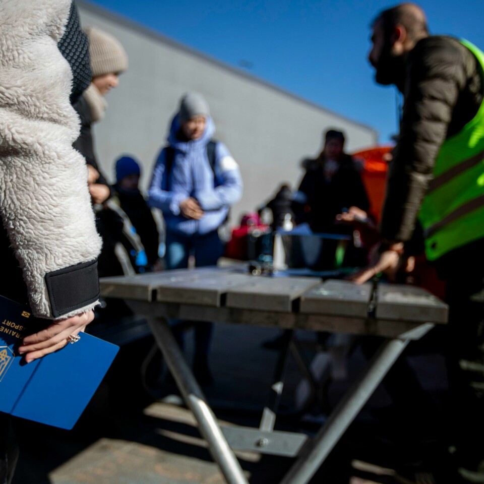 MANGE: Det er kommet nesten 10.000 ukrainere til Norge så langt. I tiden framover kan det komme mellom 10.000 og 11.000 til, mener UDI. Bildet er av en hånd som holder ett ukrainsk pass. Folk står i kø for å registrere seg på Nasjonalt mottakssenter i Råde. Foto: Javad Parsa / NTB