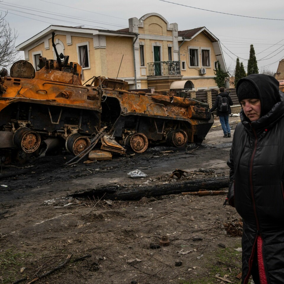 KRIG: En kvinne går ved siden av en russisk tanks. Bildene fra Butsja har sjokkert en hel verden. En kvinne passerer en ødelagt russisk stridsvogn i Butsja. Foto: Rodrigo Abd / AP / NTB