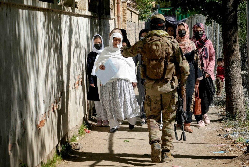AFGHANISTAN: En Talibansoldat stanser kvinner på vei inn på regjeringens passkontor. Kvinner får stadig mindre rettigheter i Afghanistan. Bildet viser en Talibansoldat som stanser kvinner på vei inn på regjeringens passkontor. Kvinner får stadig mindre rettigheter i Afghanistan.