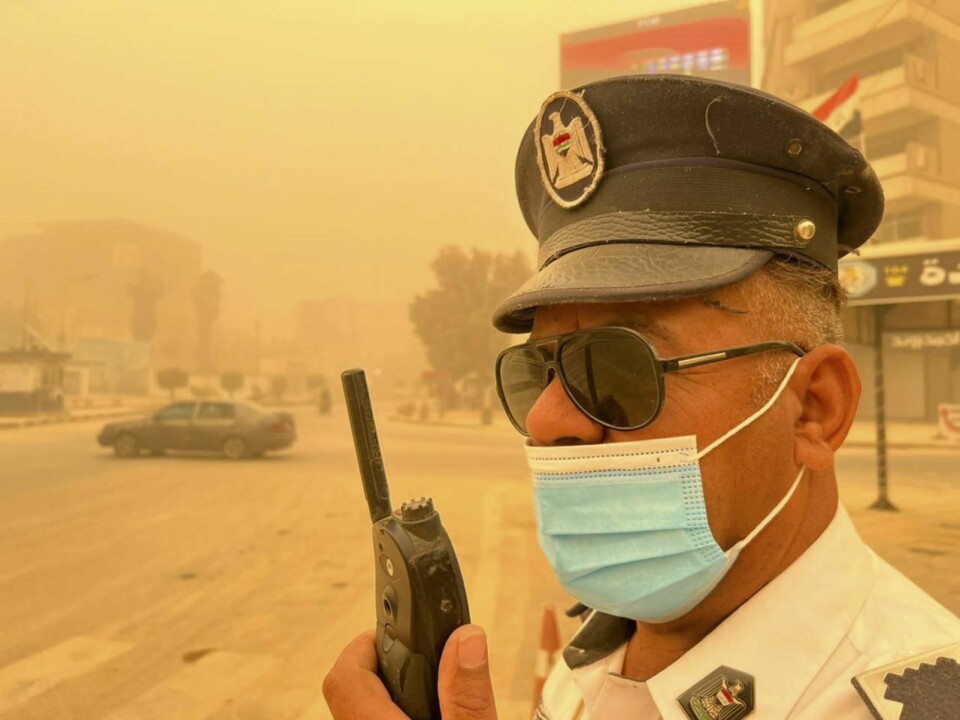 SAND: Flere tusen irakere fikk vansker med å puste etter en sandstorm denne uka. Uværet har ført til at myndighetene har mer beredskap. Foto: Ali Abdul Hassan / AP / NTB Bildet er av en politimann som er dekket av sand og støv i Bagdad torsdag. Tusenvis har fått pusteproblemer på grunn av stormen. Han står med munnbind og solbriller, og snakker i en mobiltelefon. Foto: Ali Abdul Hassan / AP / NTB