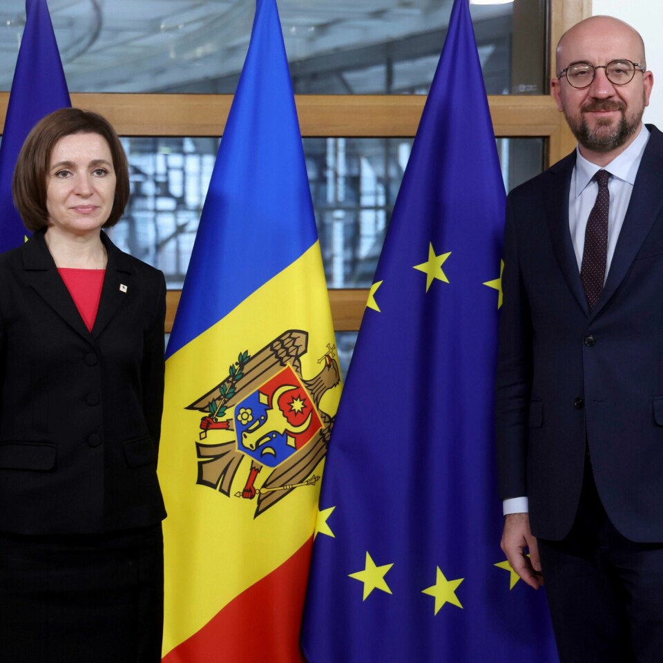 STØTTE: Charles Michel lover at EU vil støtte Moldova militært. Bildet er av Maia Sandu og Charles Michel. De står foran flaggene til Moldova og EU. Sandu er president i Moldova og Michel i EU. EU-flagget er blått, med en sirkel gule stjerner. Moldovas flagg er delt i tre fra topp til bunn. Til venstre er det blått. I midten er det gult. Og til høyre er det rødt. I midten er også en ørn og et våpenskjold. Arkivfoto: Kenzo Triboillard / AP / NTB