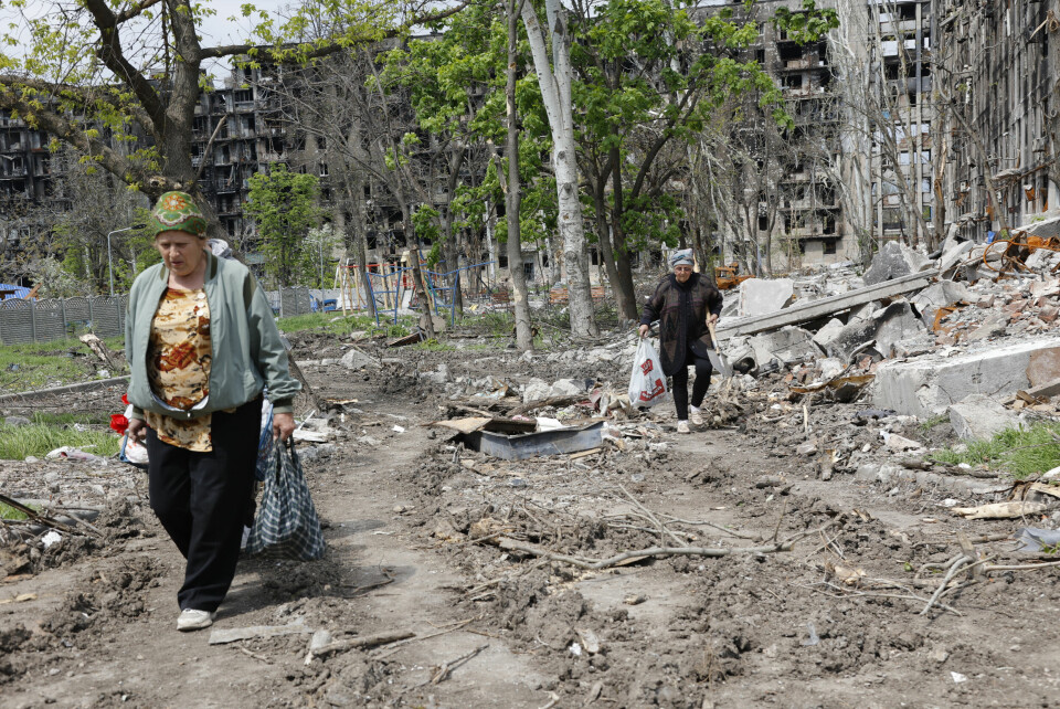 Women walk past a destroyed apartment building in Mariupol, in territory under the government of the Donetsk People's Republic, eastern Ukraine, Monday, May 2, 2022. (AP Photo/Alexei Alexandrov) En kvinne ved en ødelagt bygning i Mariupol. Hvis Russland massemobiliserer, kan det bety at brutaliteten i Ukraina økes, mener forsker. Foto: Aleksej Aleksandrov / AP / NTB