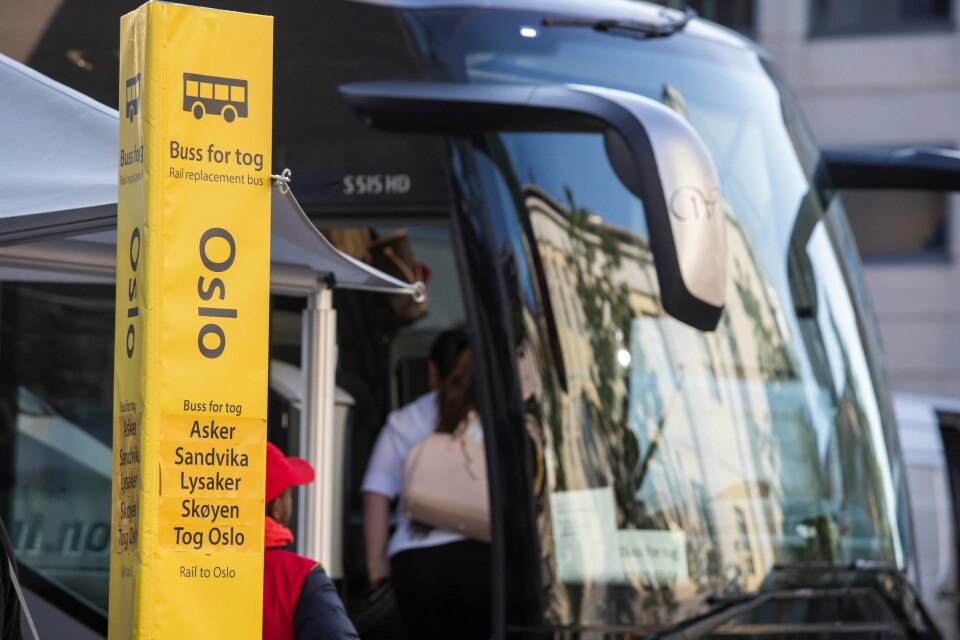 BUSS: Det blir buss for tog i sommer også. Se oversikten nederst i saken. Bildet er av en buss. Foran den er det en gul informasjonssøyle. Der står det Oslo, og at det er buss for tog. Foto: Terje Bendiksby / NTB