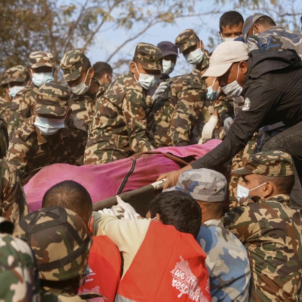 FLYSTYRT: Redningsarbeidere henter ut en av de døde etter flystyrten i Nepal søndag. Bildet viser redningsarbeidere som henter ut en av de døde etter flystyrten i Nepal søndag.