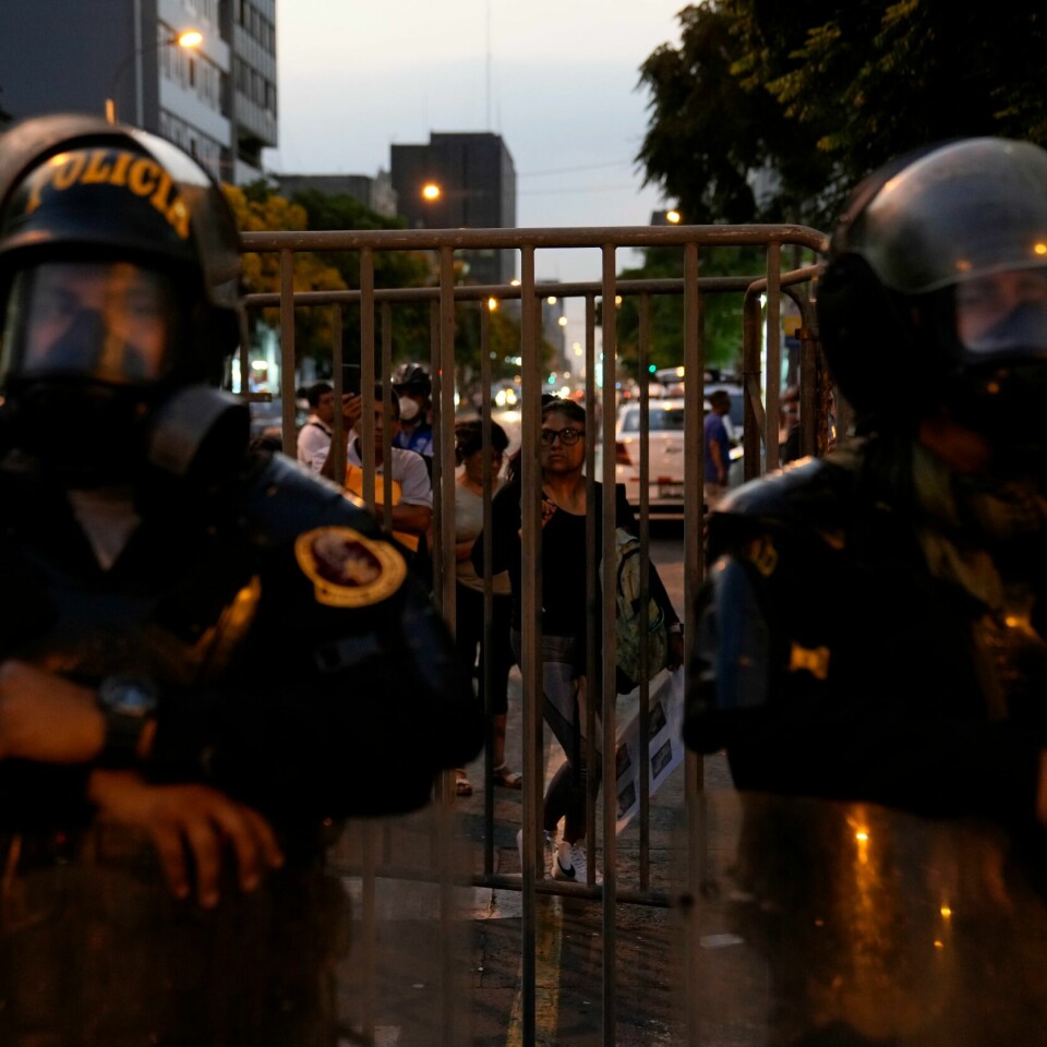 SPERRE: Politiet har sperret av en vei til kongressen i Peru. De siste ukene har det vært mange og store protester i landet. Politiet blokkerer en vei til kongressbygningen i Lima i Peru tirsdag. Foto: Martin Mejia / AP / NTB