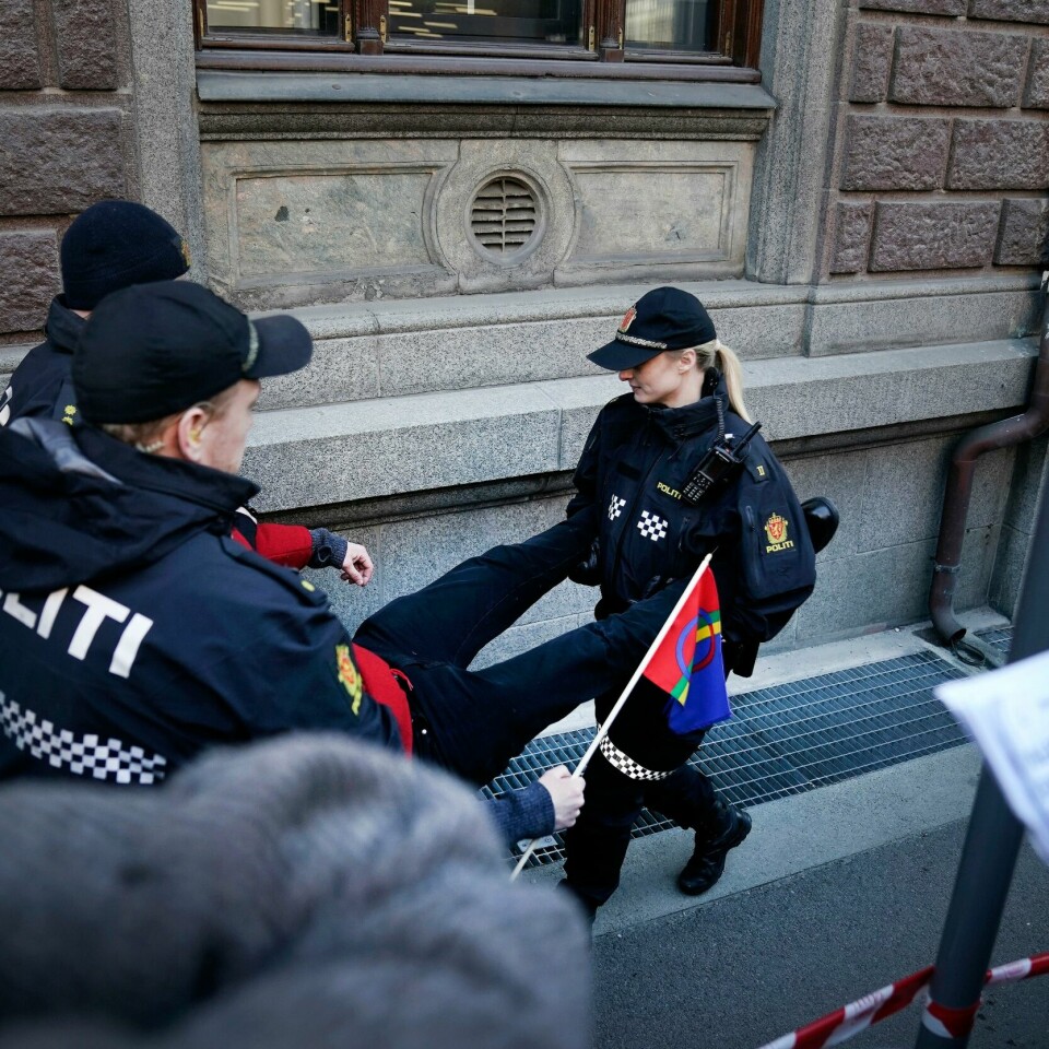 POLITIET: Politiet bærer aksjonister bort fra regjeringskvartalet i Oslo mandag. Bildet viser en demonstrant som blir båret bort av politiet i Oslo.