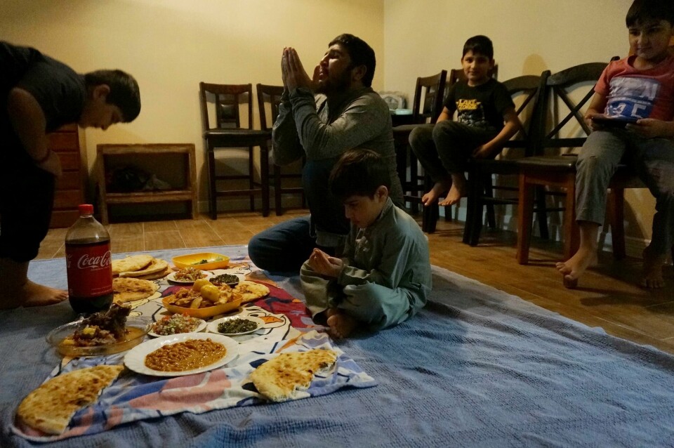 RAMADAN: Å bryte fasten etter solnedgang er en del av ritualet under fastemåneden ramadan. Muslimer over hele verden faster. Men vi kan faste av flere grunner enn islam. Shel Alam Momand framsier en bønn før han bryter ramadanfasten i leiligheten i El Paso i Texas. Han og familien er blant tusenvis av afghanere som ble evakuert fra landet da Taliban tok makten i fjor høst. Foto: Giovanna Dell'Orto / AP / NTB