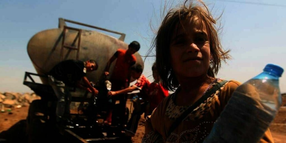 FLUKT: En ung irakisk flyktning fyller vann i flyktningeleiren Newroz i Syria. Tusener har kommet hit og til andre leirer etter at IS har jaget 1,2 millioner mennesker på flukt i Irak.