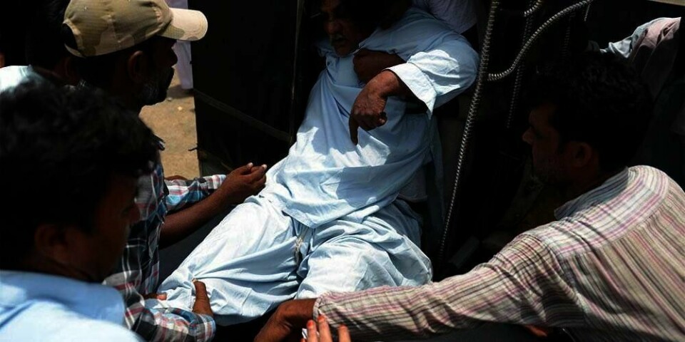 HJELP: Mannen på bildet trenger hjelp. Han fraktes til sykehus i byen Karachi sør i Pakistan. Over 450 mennesker er døde på grunn av varmt vær de siste tre dagene.