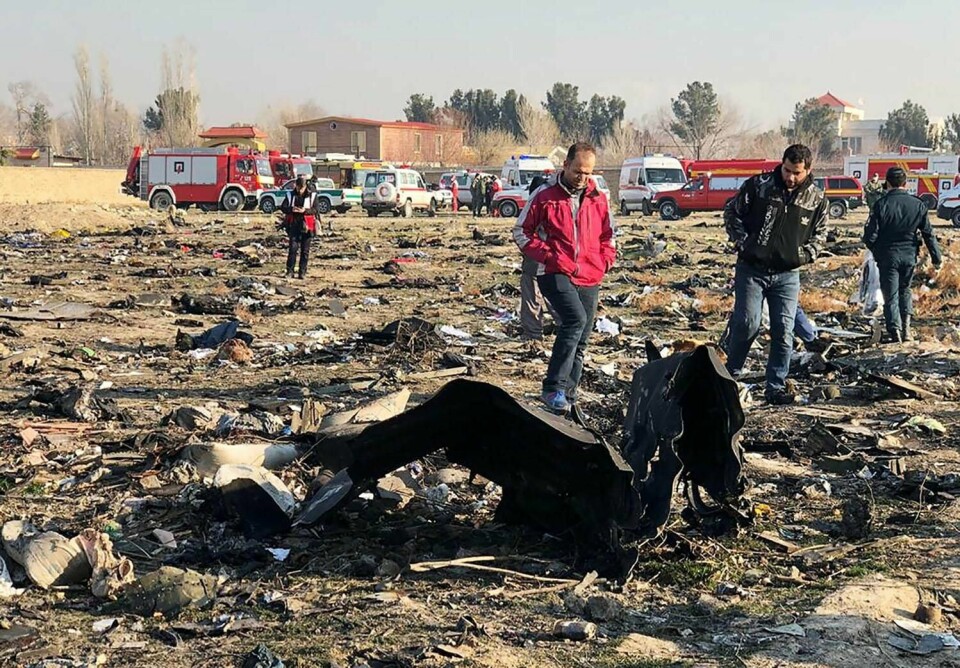 STYRTET: Et fly styrtet i Iran. Det var på vei til Ukraina. Minst 170 mennesker i flyet er trolig døde. Bildet viser folk som står ved siden av flyvraket.