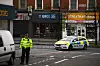 Bildet viser politibil og politisperringer i Streatham i London etter at to personer ble knivstukket søndag.