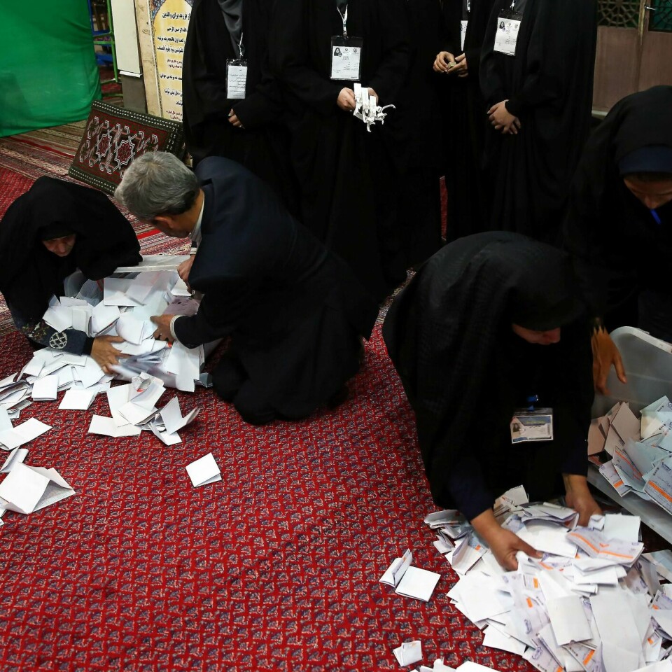 VALG: Iranerne valgte ny nasjonal-forsamling fredag. Mange droppet å bruke stemme-retten. Her tømmer de ut bokser med sedler. Foto: Nazanin Tabatabaee / WANA / NTB scanpix