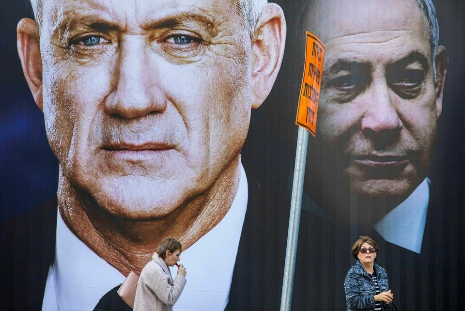 VALG: Folk går forbi valgplakater. Israelerne skal velge mellom partiet Blått og hvitt, som ledes av Benny Gantz ( til venstre). Statsminister Benjamin Netanyahu i partiet Likud er til høyre.
