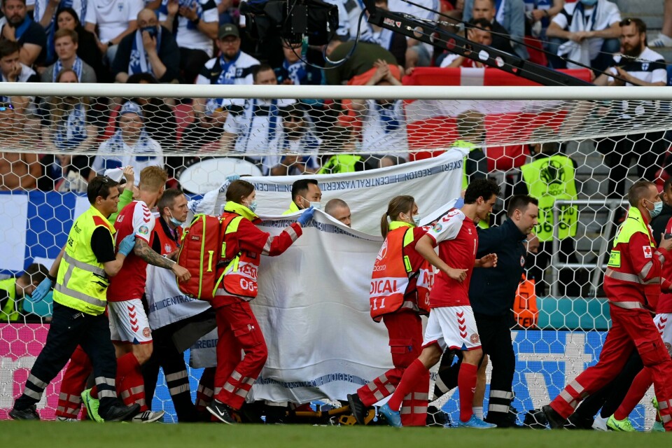 KOLLAPSET: Danmarks stjernespiller Christian Eriksen falt sammen på fotballbanen. Det skjedde i EM-kampen mot Finland lørdag. Bildet viser Christian Eriksen som blir båret ut fra fotballbanen.
