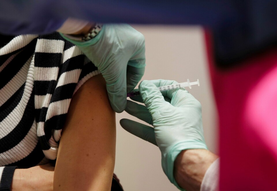 VAKSINE: Det er for tidlig å åpne hele samfunnet i Europa, mener WHO. Vaksineringen har ikke kommet langt nok til å stoppe nye utbrudd, mener de. Bildet viser to hender som setter en koronavaksine i en arm.