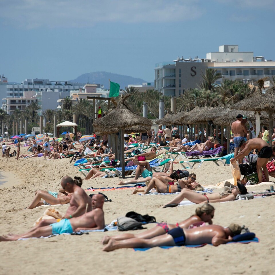 FERIE: Slik så det ut på en strand på Mallorca i Spania i forrige uke. Men kun én av ti nordmenn sier de vil ta sommerferien i utlandet. Det viser en undersøkelse. Bildet viser folk som soler seg på en strand på Mallorca i Spania.