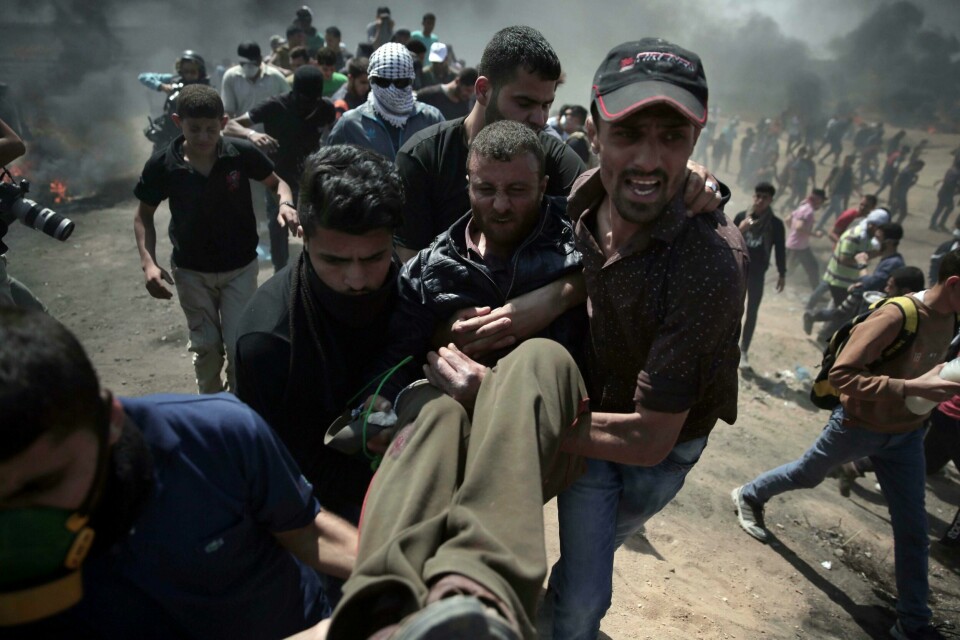 SKADD: Palestinske demonstranter frakter bort en skadd person. Minst 25 personer er drept hittil mandag. De demonstrerer mot at USAs ambassade flyttes til Jerusalem.
