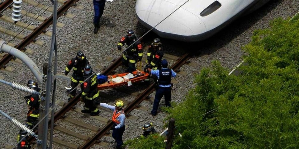 SKADD:  Her blir en av de skadde passasjerene fraktet ut av toget i båre. Det ble kaos i toget da en mann tømte olje over seg selv. Togvognen ble fylt med røyk.