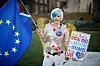 Bildet viser en kvinne med pynt og plakat som er imot brexit.