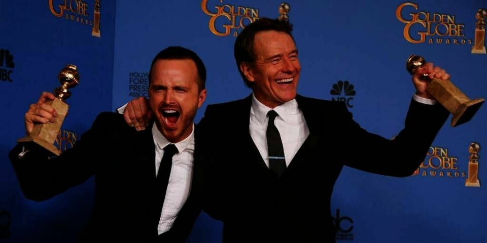 GLADE VINNERE: Skuespilleren Bryan Cranstone står til høyre. Han er glad for å ha vunnet prisen for beste mannlige skuespiller. Det fikk han for rollen i TV-serien Breaking Bad. Til venstre står skuespiller Aaron Paul. De feirer også at Breaking Bad ble kåret til beste TV-serie.