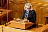 Bildet er av justisminister Monica Mæland. Hun står på en talerstol i Stortinget.