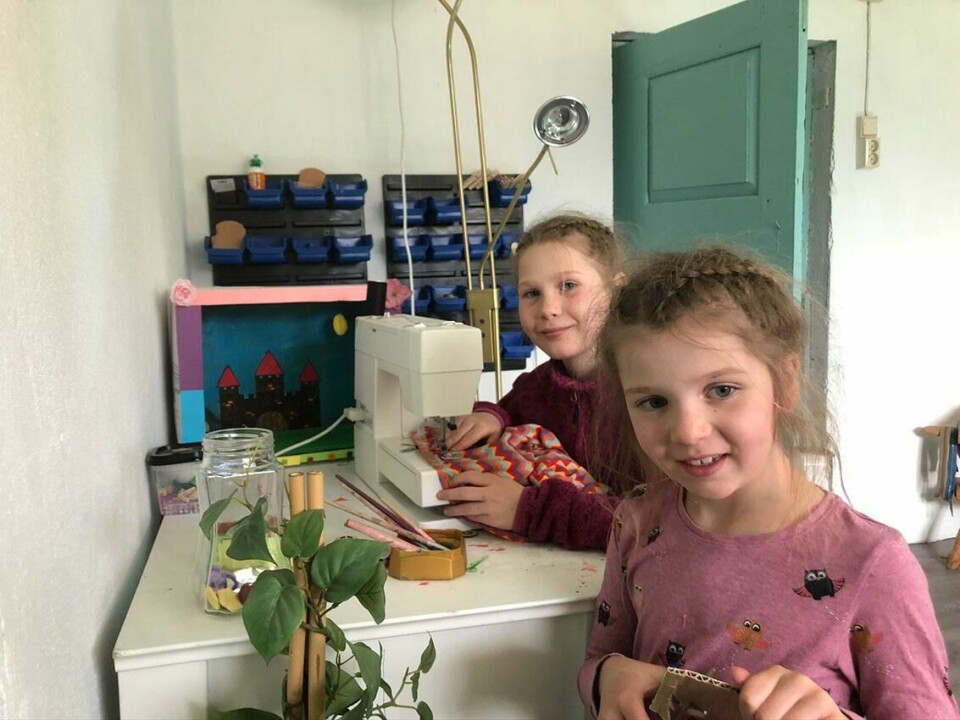 PRAKTISK: Tiril på ni år (til venstre) og Kari på sju får gjøre praktiske ting, som å sy. Bildet viser ni år gamle Tiril og sju år gamle Kari ved en symaskin.