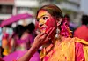 Bildet viser en indisk kvinne med maling i ansiktet, fra festivalen Holi i India.