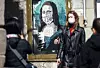 Bildet viser en kvinne med munnbind, foran et bilde av Mona Lisa med munnbind.