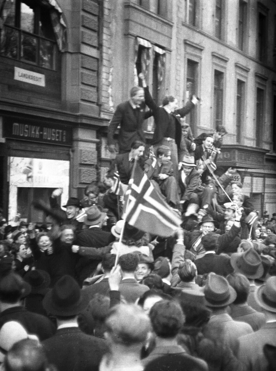 Oslo 19450508: Fredsdagene mai 1945. Frigjøringsdagen 8. mai, jubel på Karl Johans gate. Biler fulle av jublende mennesker med norske flagg, folkemengder i gatene.Foto: Kihle / NTB / Scanpix Oslo 19450508: Fredsdagene mai 1945. Frigjøringsdagen 8. mai, jubel på Karl Johans gate. Biler fulle av jublende mennesker med norske flagg, folkemengder i gatene.
Foto: Kihle / NTB / Scanpix