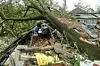 A man salvages items from his house damaged by cyclone Amphan in Midnapore, West Bengal, on May 21, 2020. - At least 22 people died as the fiercest cyclone to hit parts of Bangladesh and eastern India this century sent trees flying and flattened houses, with millions crammed into shelters despite the risk of coronavirus. (Photo by Dibyangshu SARKAR / AFP)