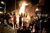 People stand outside the Minneapolis police 3rd Precinct building after fires were set at the building, Thursday, May 28, 2020, in Minneapolis, during demonstrations over the death George Floyd on Monday in Minneapolis police custody. (Carlos Gonzalez/Star Tribune via AP)