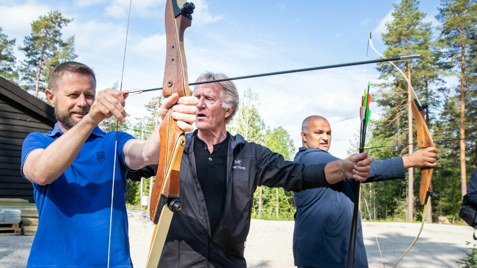 AKTIVITET: Helse- og omsorgsminister Bent Høie besøkte Liastua i Groruddalen torsdag. Arne Fagerlie viser hvordan ministeren kan skyte med pil og bue. Til høyre står Rashid Nawaz.
