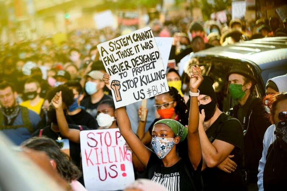 MANGE: Tusenvis av demonstranter samles i California. De har fått nok av rasisme og politivold. Bildet viser demonstranter med plakater.