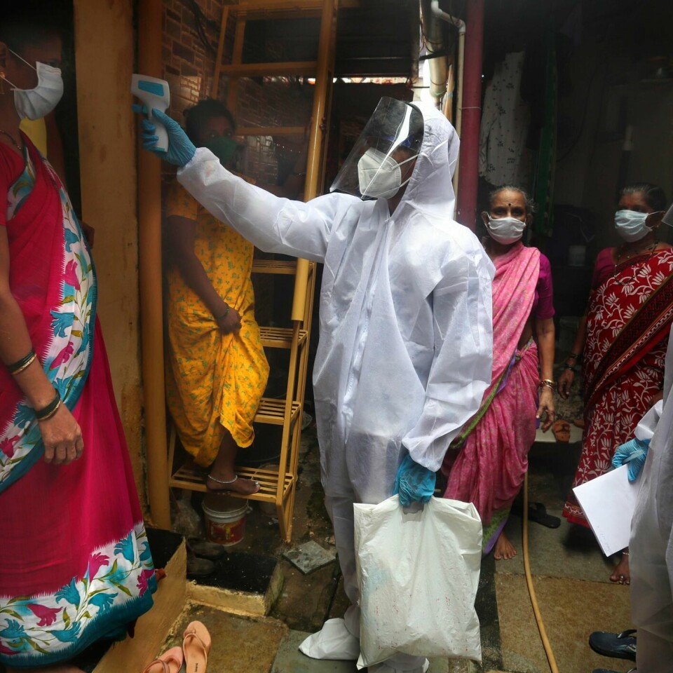 KORONAVIRUSET: En helsearbeider tar temperaturen på en kvinne i et slumområde i Mumbai.