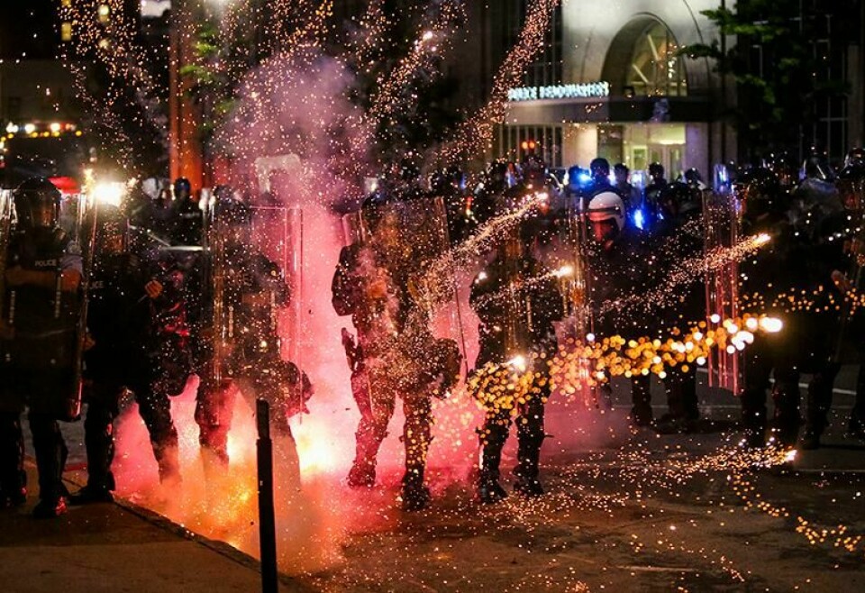 KAOS: Folk bruker fyrverkeri mot politiet. Fireworks go off in front of police, who with protesters in front of police headquarters in St. Louis on Monday, June 1, 2020. The small group of protesters was originally part of a much larger group demonstrating earlier in the afternoon against the death of George Floyd. (Colter Peterson/St. Louis Post-Dispatch via AP)