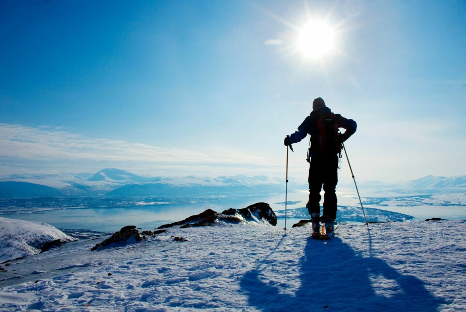 TROMSØ 20100330.
Påske-turist Brynjar Lien Schulerud på toppen av fjellet Rødtinden på 470 moh som ligger rett utenfor Tromsø i Troms. Strålende solskinn har sørget for en god påskestart i nord, mens det skal bli gråvær sørover i landet. Skiløper på fjellet, i motlys. Sol og blå himmel i bakgrunnen.
Foto: Kyrre Lien / Scanpix