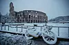 Bildet viser snø ved Colosseum i Roma i Italia.