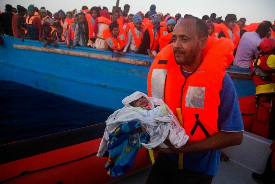 REDDET: En mann holder sin fem dager gamle sønn. De har nettopp blitt reddet utenfor kysten av Libya.