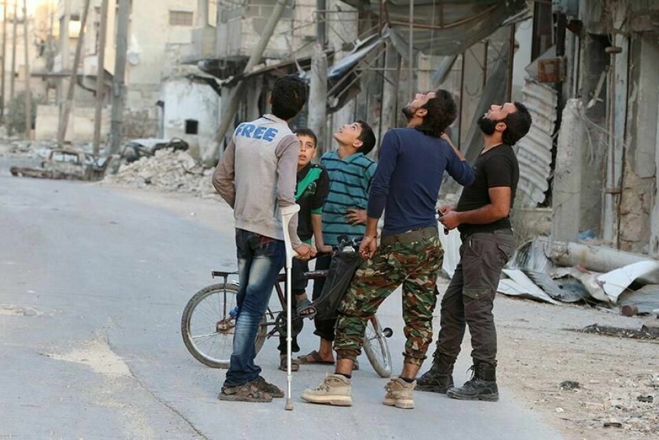 ANGREP: Folk i Aleppo ser etter fly. De frykter nye angrep. To sykehus ble bombet i Aleppo i Syria onsdag. De siste dagene har det vært flere angrep. Det gjelder områdene som styres av opprørerne.