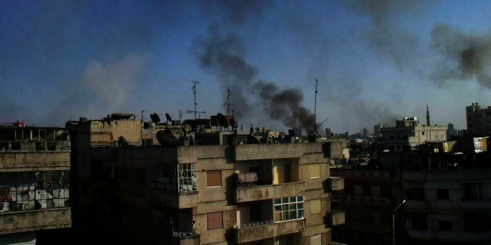 ANGREP: Røyk stiger opp fra byen Homs i Syria 8. april. Tirsdag skulle fredsplanen begynne å virke. Men ingenting tyder på at regimet har tenkt å gjøre det de har lovet.
