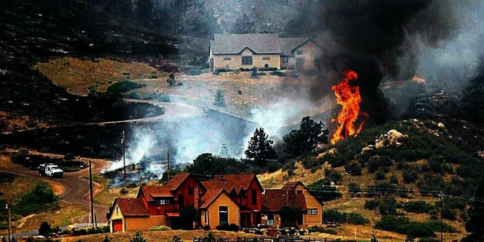 BRANN: Flammene nærmer seg et hus i nærheten av byen Laporte i delstaten Colorado i USA. En stor skogbrann herjer i delstaten.