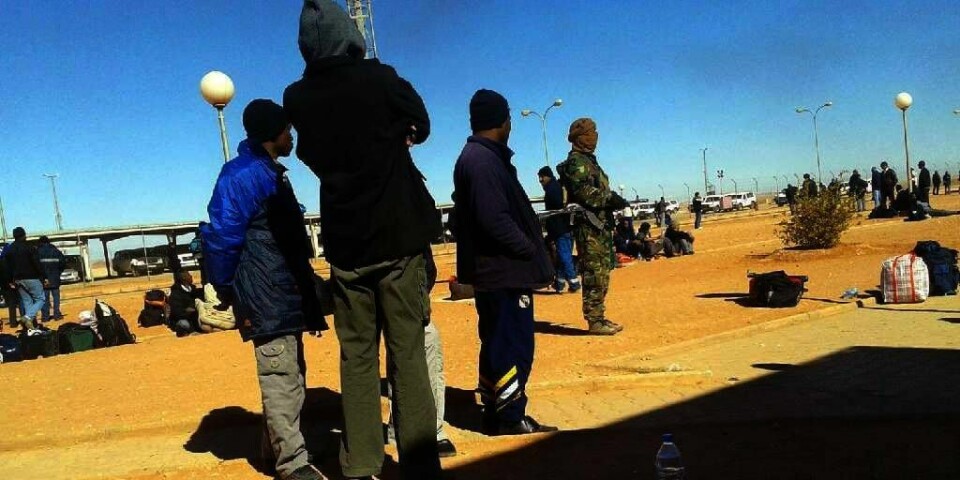 TERRORIST: Bildet viser en av terroristene ( i midten i militære klær) under angrepet. Terroristene tvang arbeidere fra Algerie til å ta med seg tingene sine og dra fra området. Mange utlendinger ble drept. Bildet ble tatt i skjul av en algerisk arbeider.