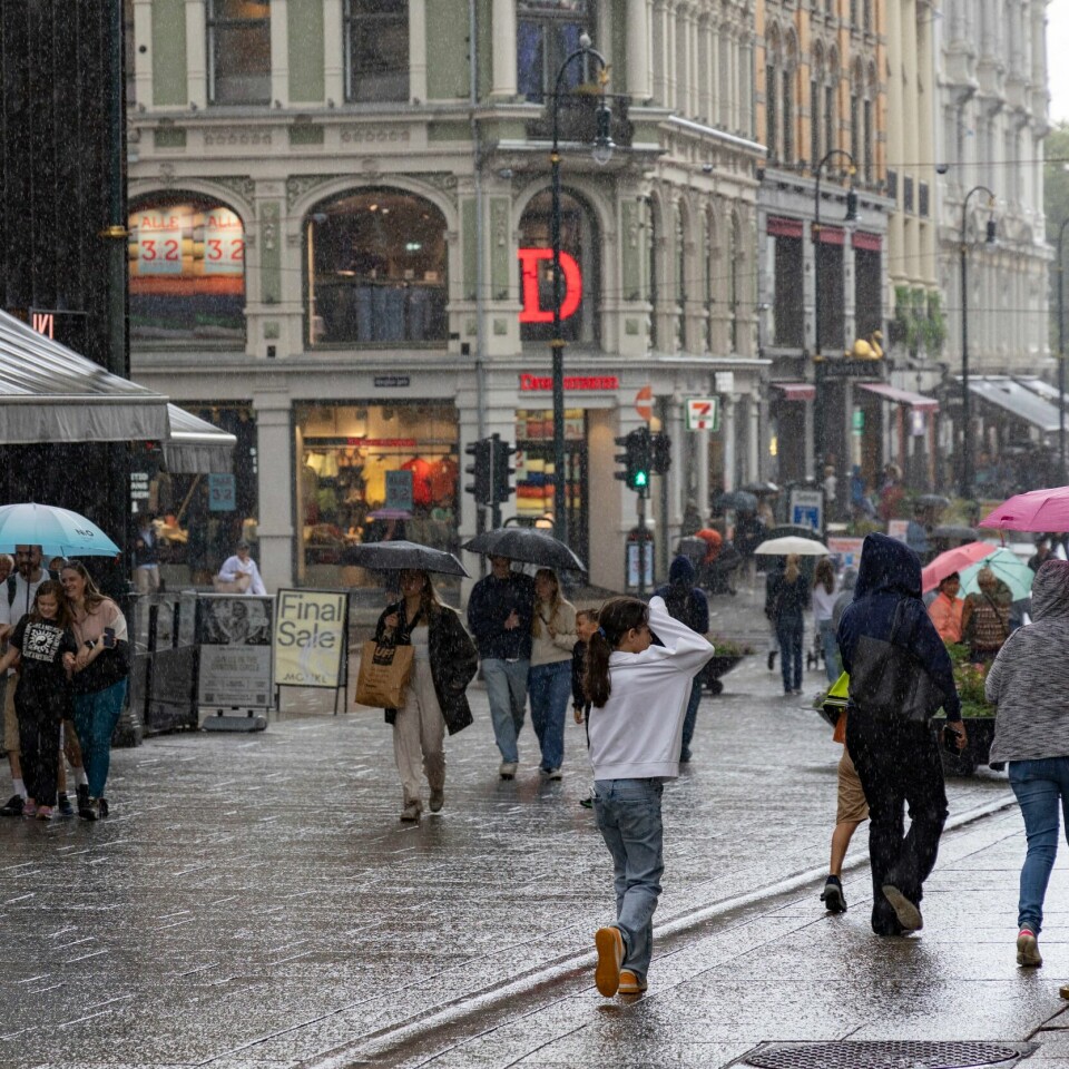 VÆR: Dette bildet ble tatt på Karl Johan i Oslo i juli i fjor. Det kunne like gjerne vært tatt i juli i år. Det er ingen tegn på at sommeren kommer tilbake med det første. Bildet viser folk i regn på Karl Johans gate i Oslo.