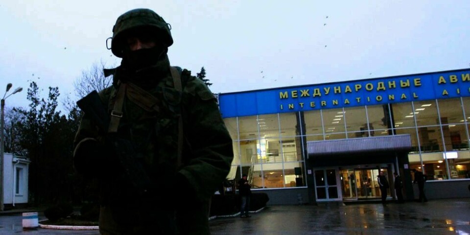KONTROLL: En mann med våpen vokter flyplassen i Simferopol i Ukraina.