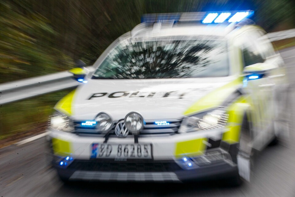 MANN I HUS: Politiet omringet en bolig i Fredrikstad torsdag. Inne i huset var en mann med våpen. Bildet viser en politibil i fart. Foto: NTB